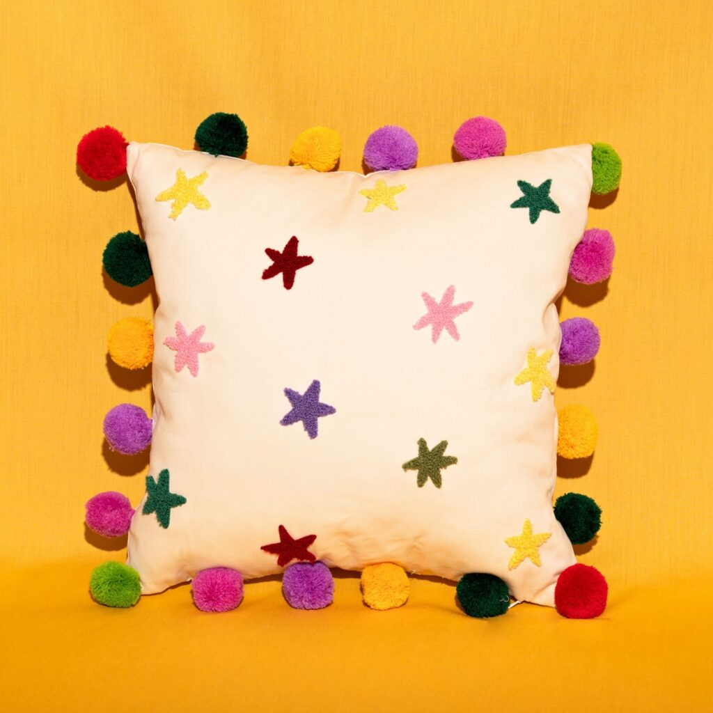 colourful pom pom cushion with stars